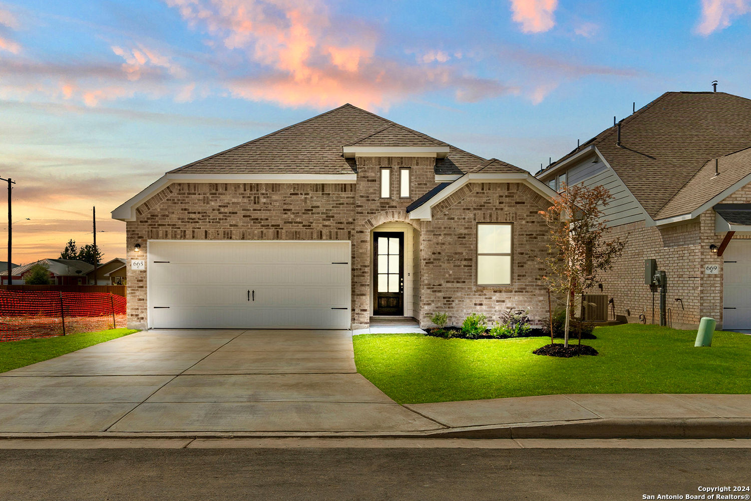 a front view of a house with a yard and trees