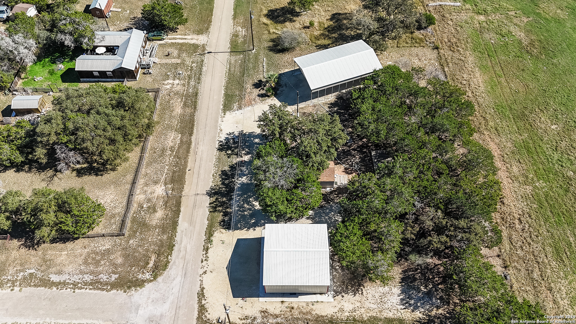 an aerial view of a house with a yard and trees