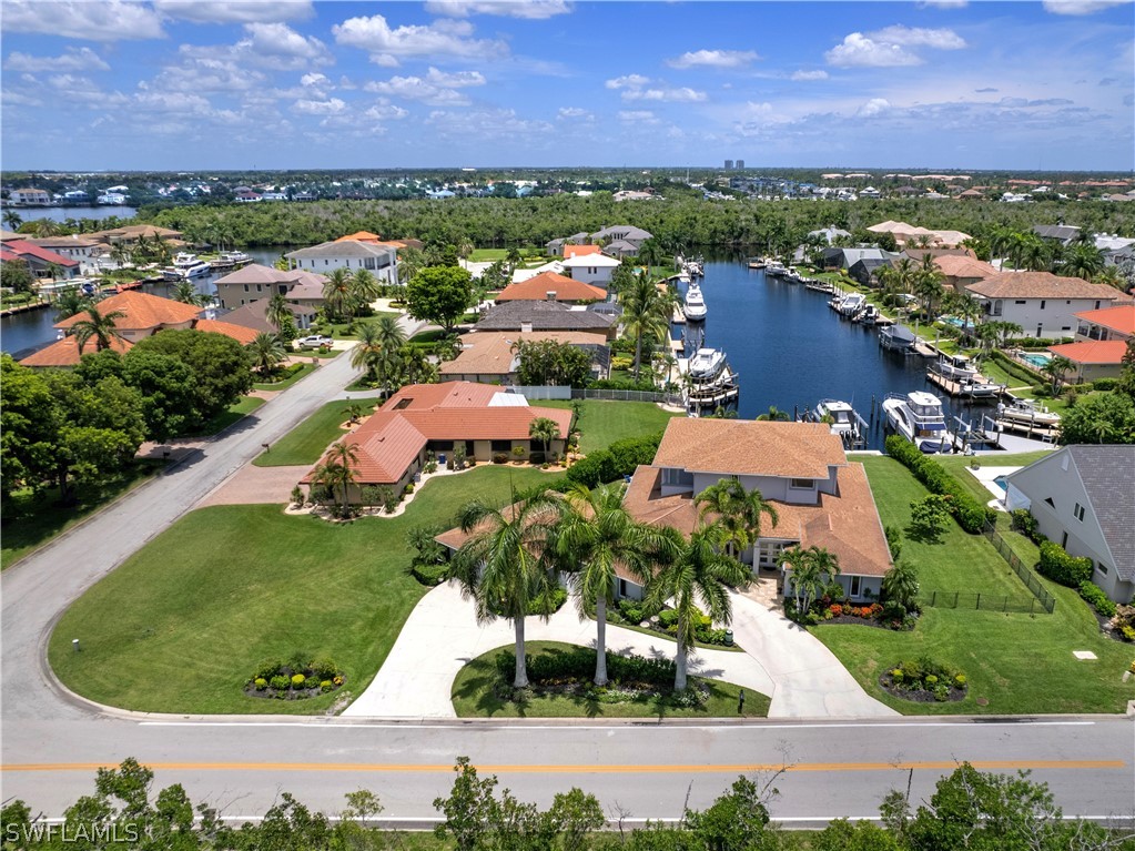 an aerial view of residential houses with outdoor space and lake view in back