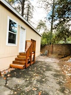 a backyard of a house with wooden fence and trees