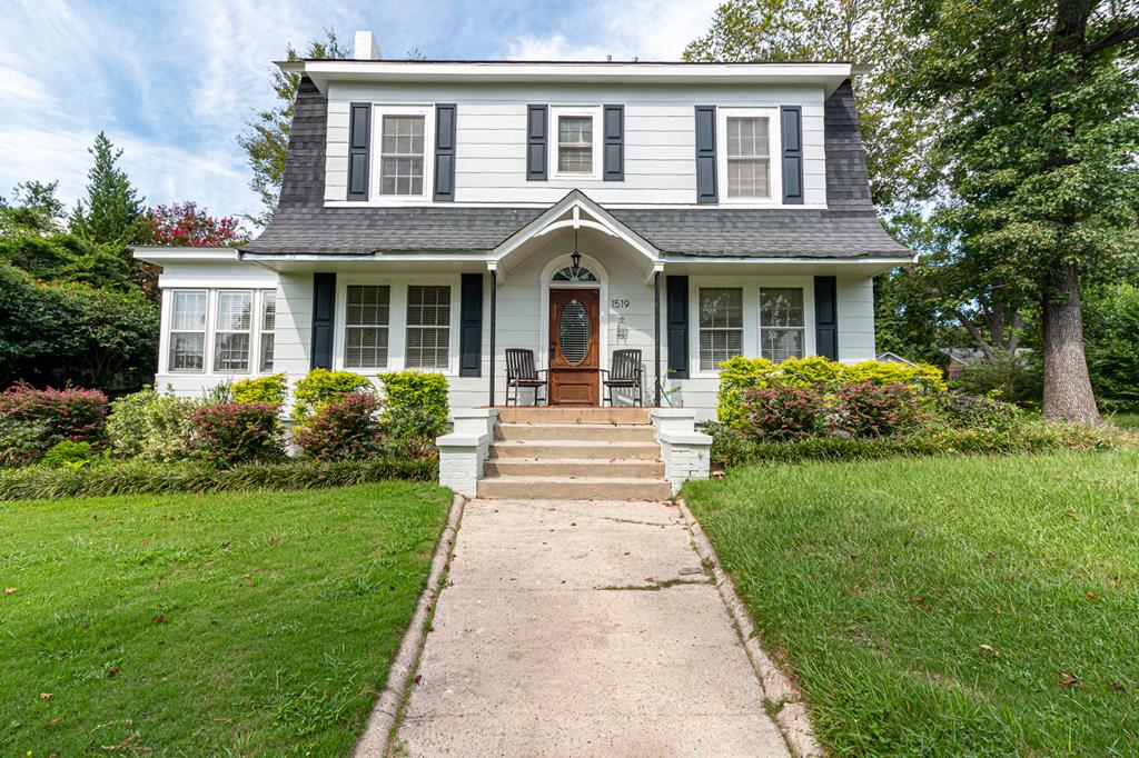 a front view of a house with garden and porch