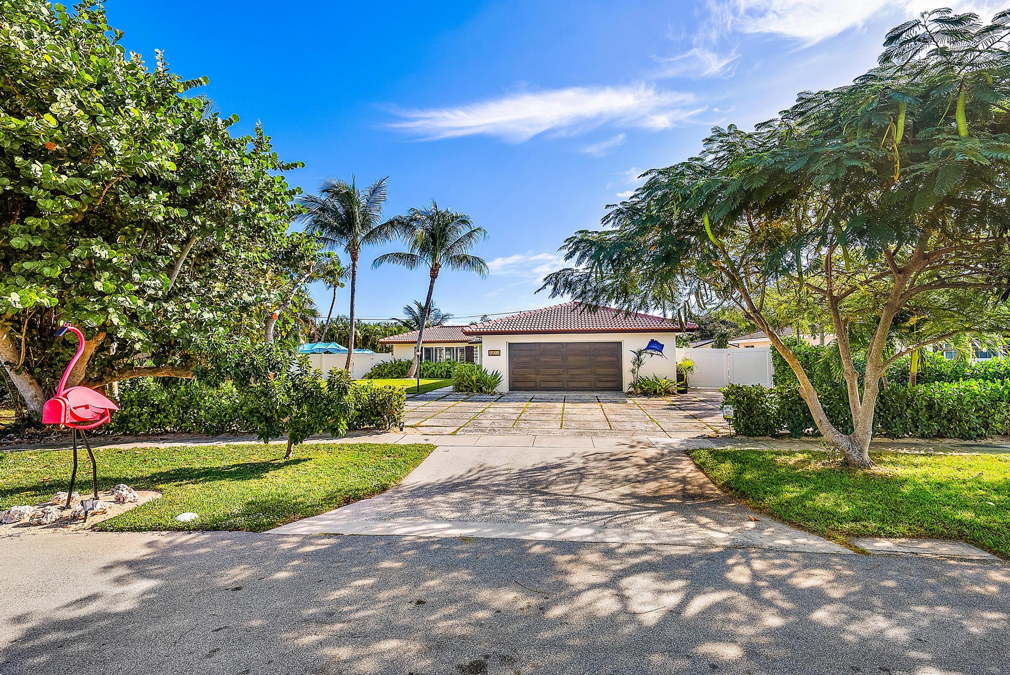 a front view of a house with a yard and trees