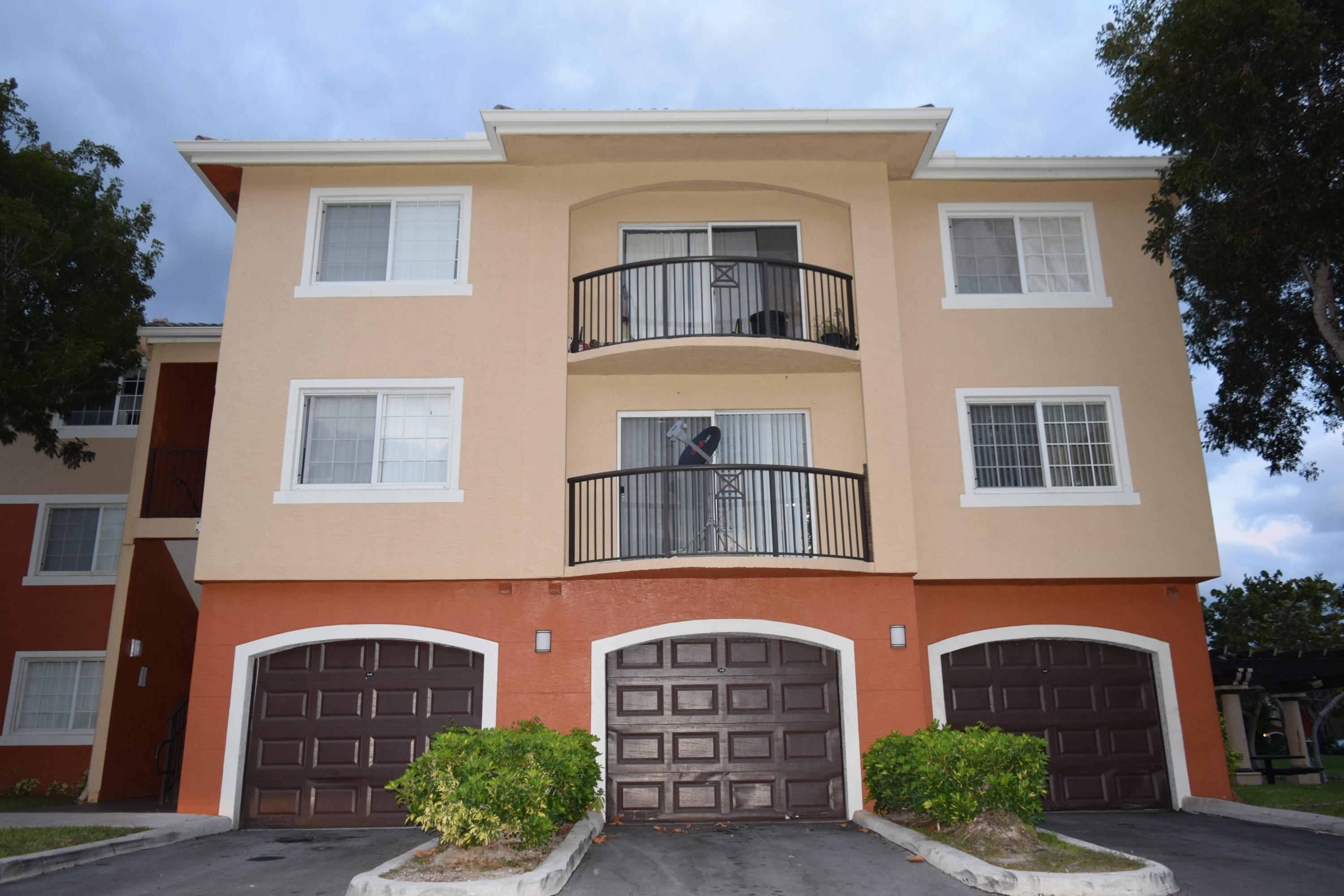 a front view of a house with yard and parking