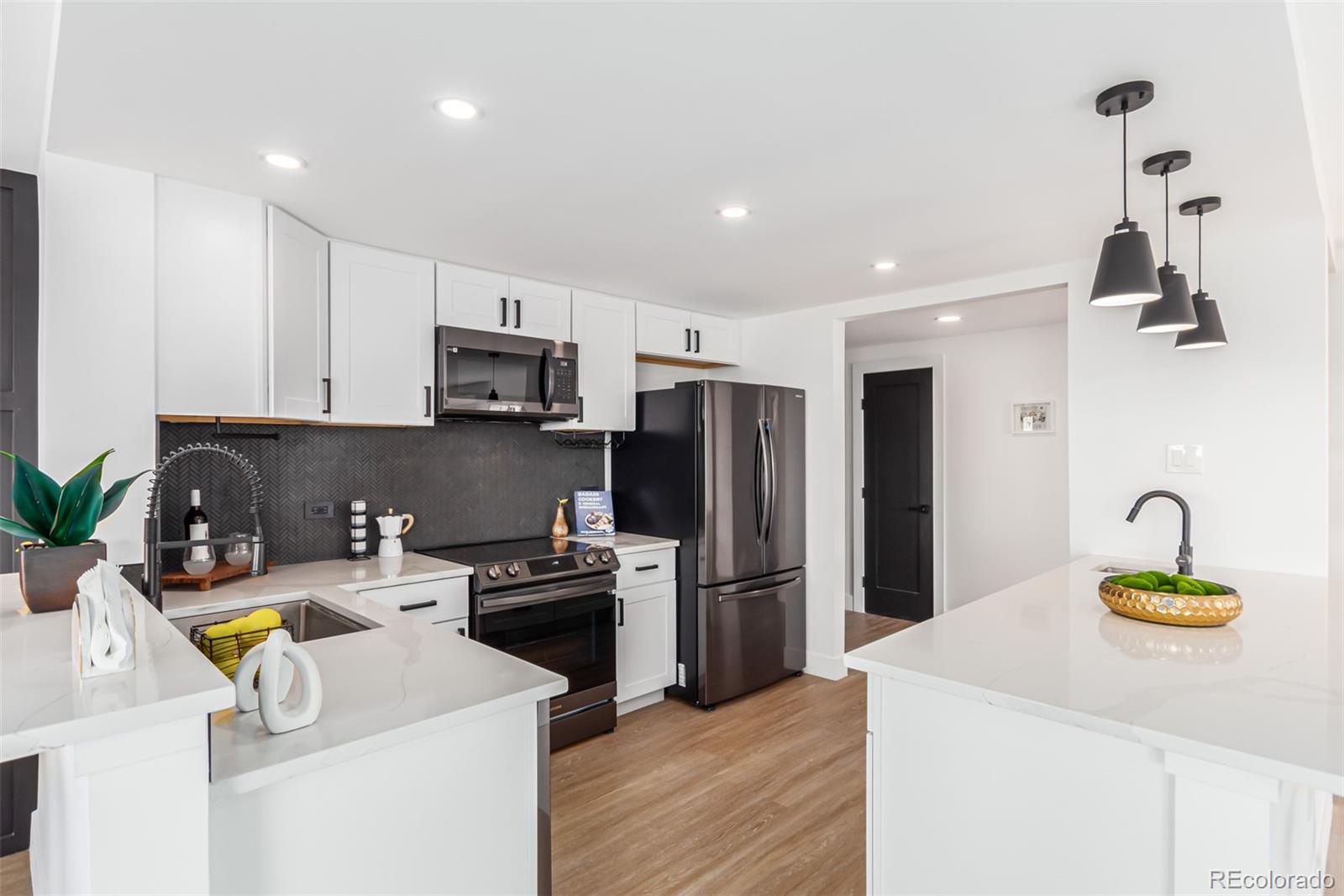 a kitchen with a sink a refrigerator and a stove top oven