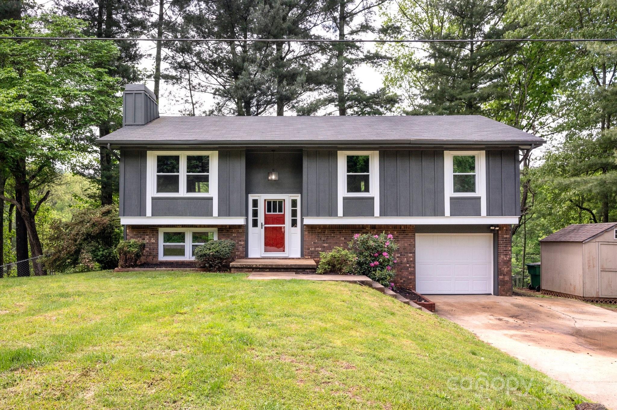 a front view of a house with a yard and trees