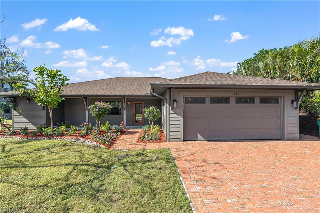 Beautiful front facade featuring a front yard and a garage