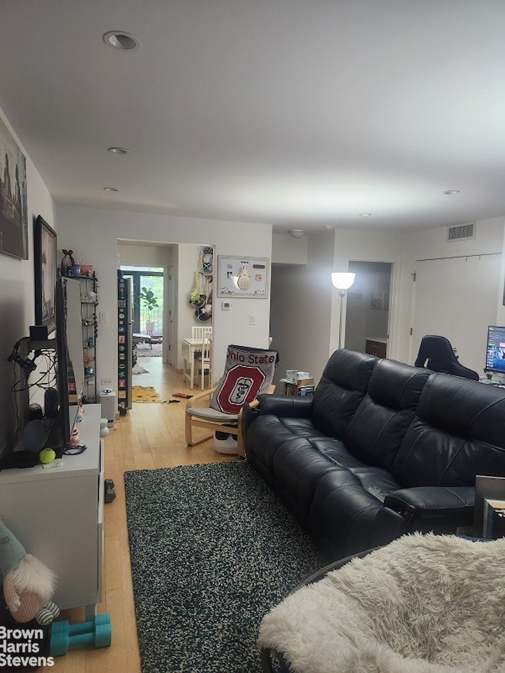 a living room with furniture and a wooden floor