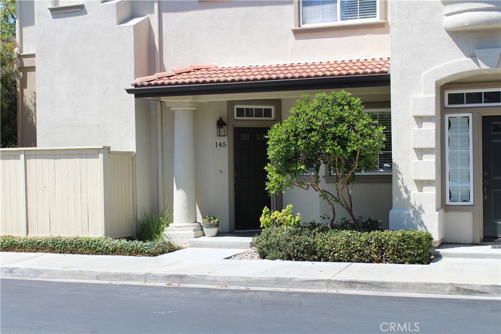 a front view of a house with a yard and potted plants