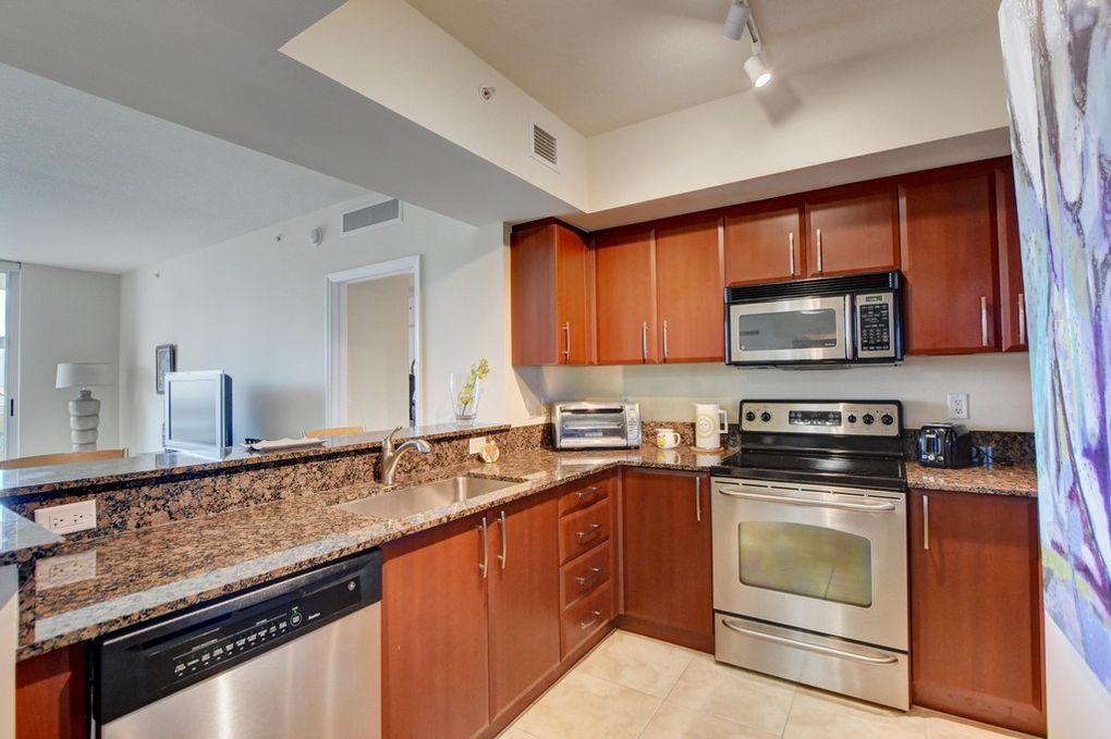 a kitchen with granite countertop a sink stainless steel appliances and cabinets