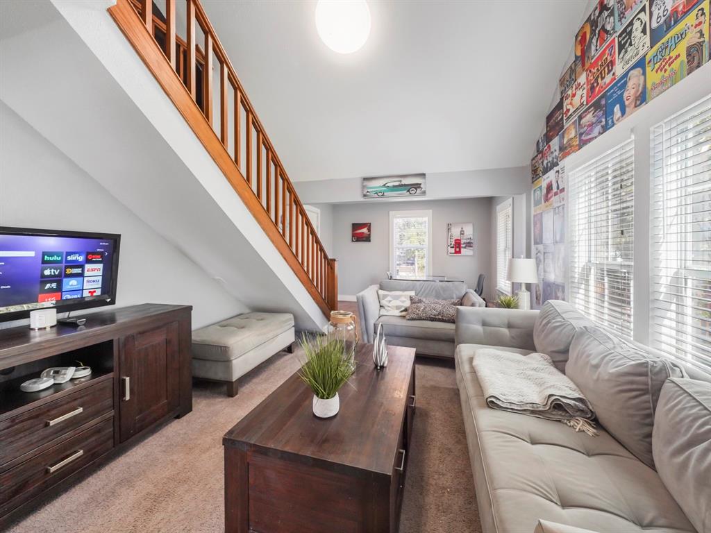 a living room with furniture and a flat screen tv with wooden floor