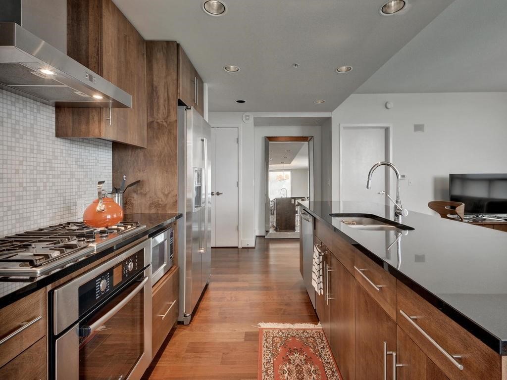 a kitchen with stainless steel appliances granite countertop a stove and a sink