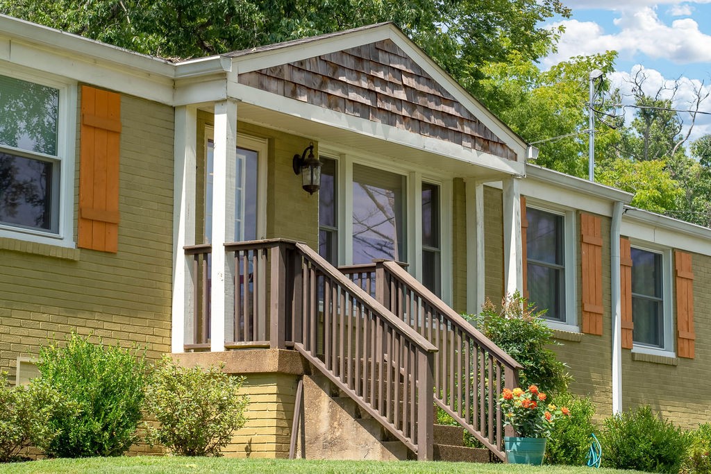 a view of a house with wooden walls and a porch