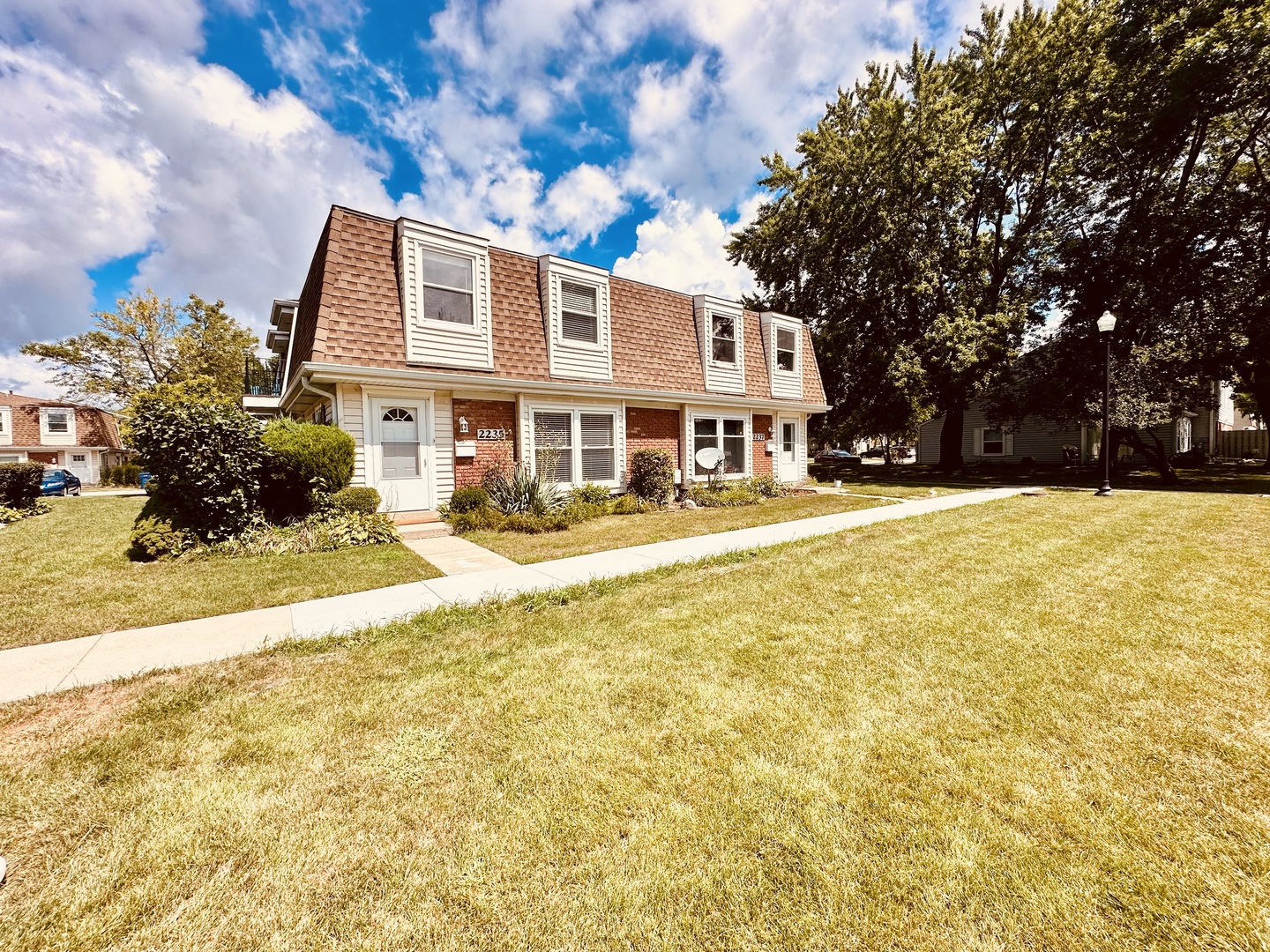 a front view of a house with a yard and trees