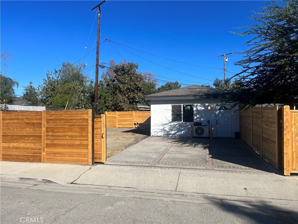 a view of a house with a tree and wooden fence