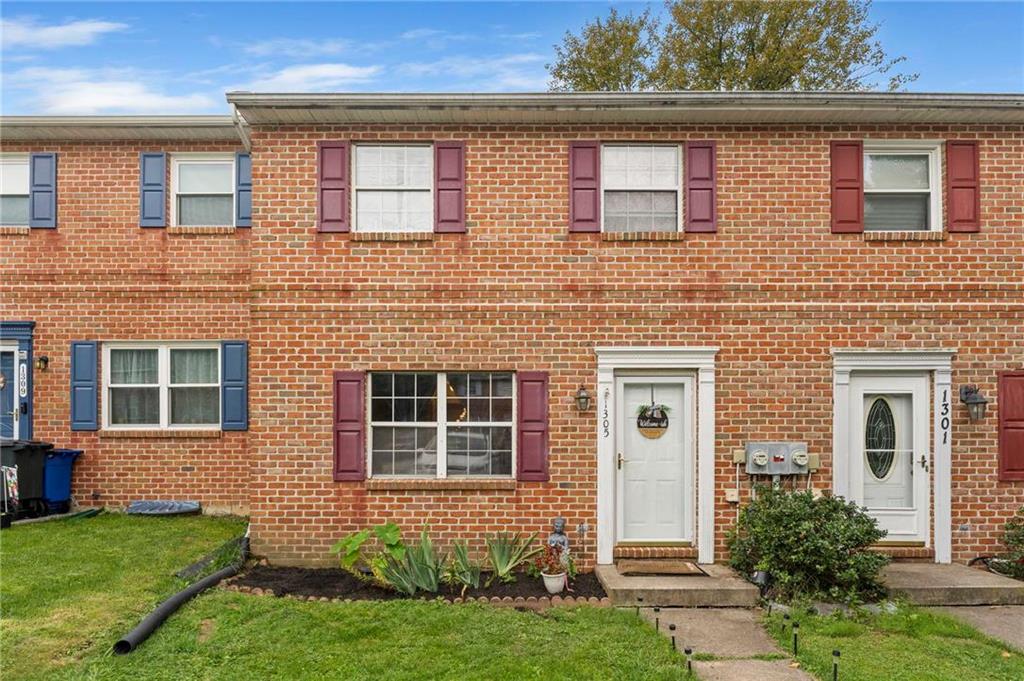 front view of a brick house with a yard