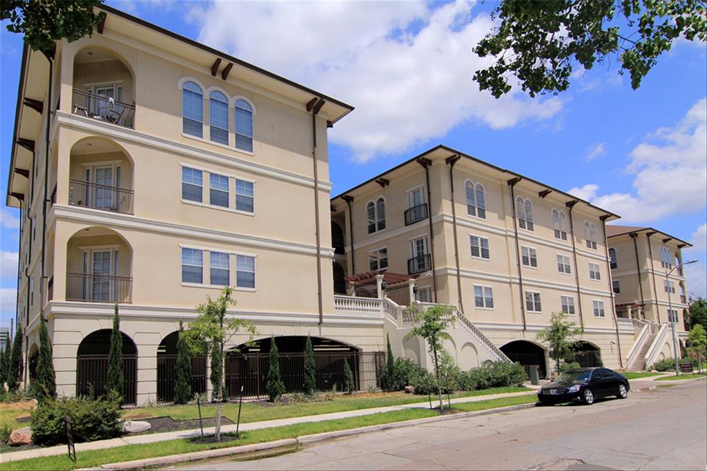 a front view of a building with lot of windows and trees