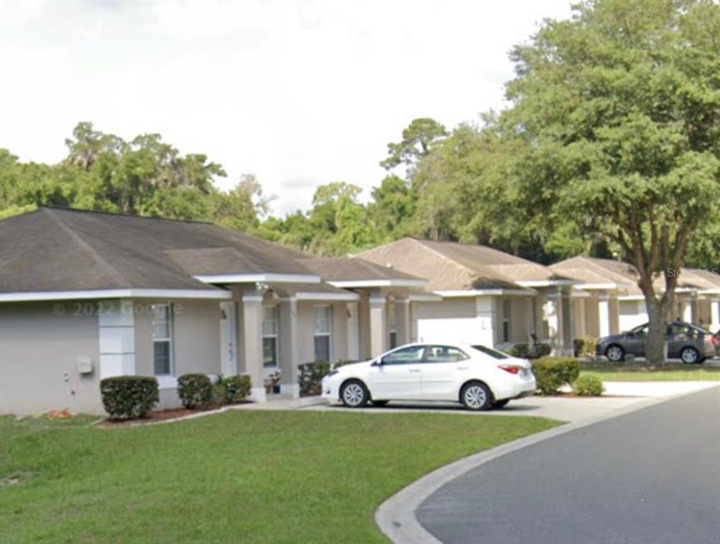 a white house covered with tall trees