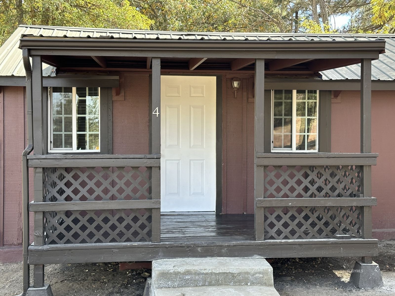 a front view of a house with a large window and wooden fence