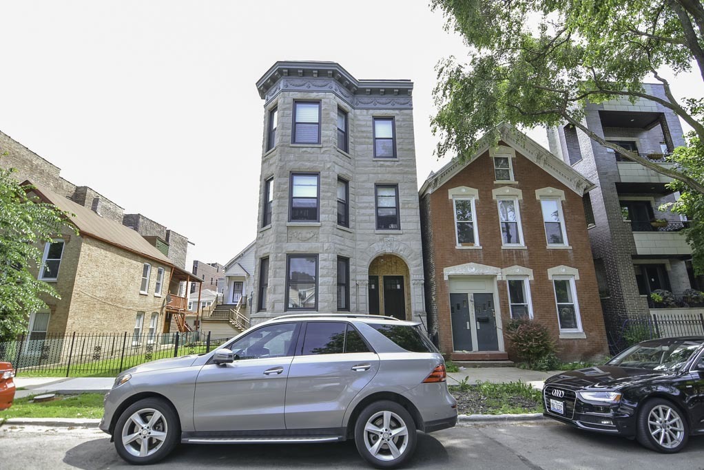 a front view of a residential apartment building with a yard