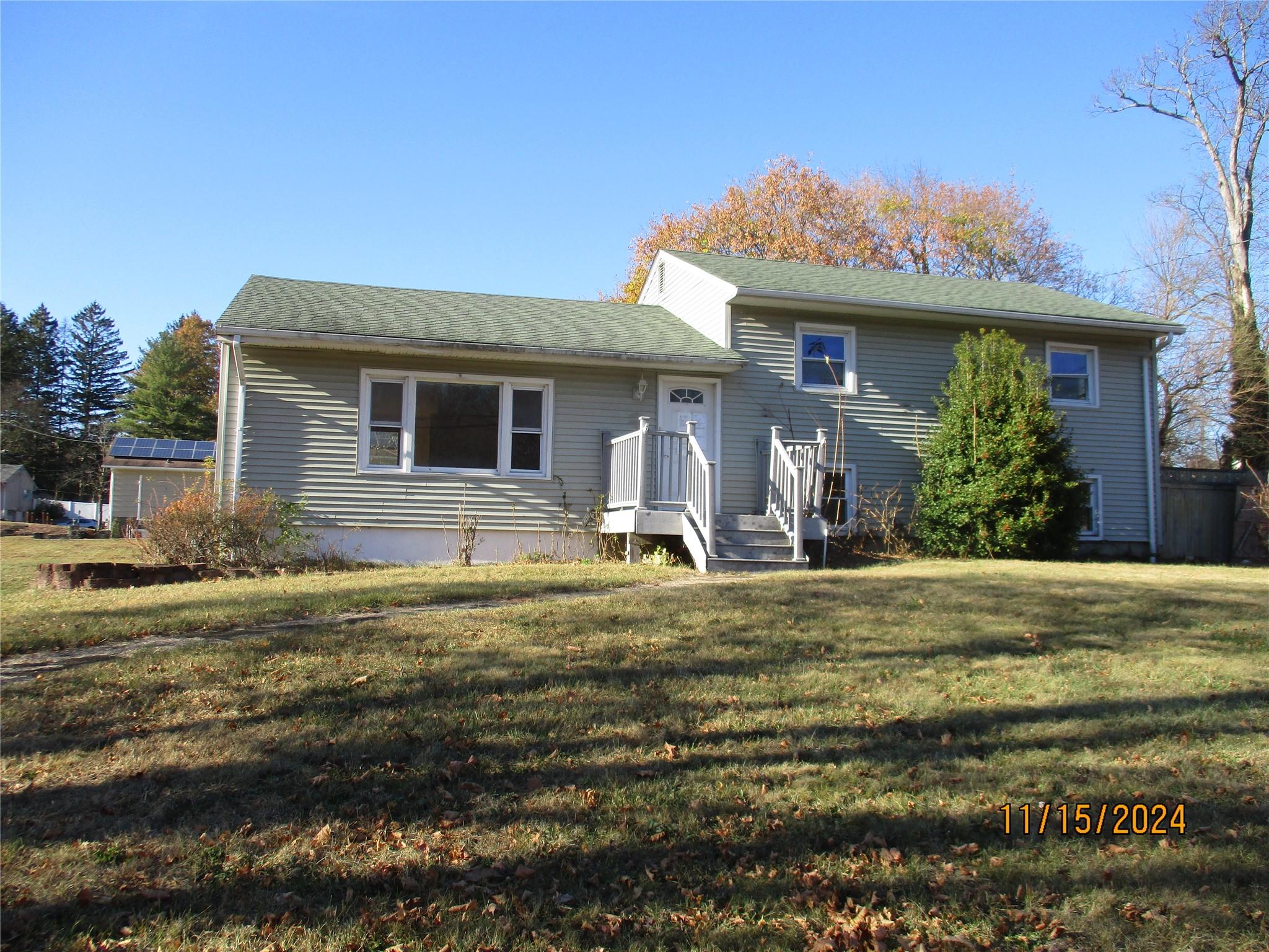 a view of a house with a yard patio and furniture