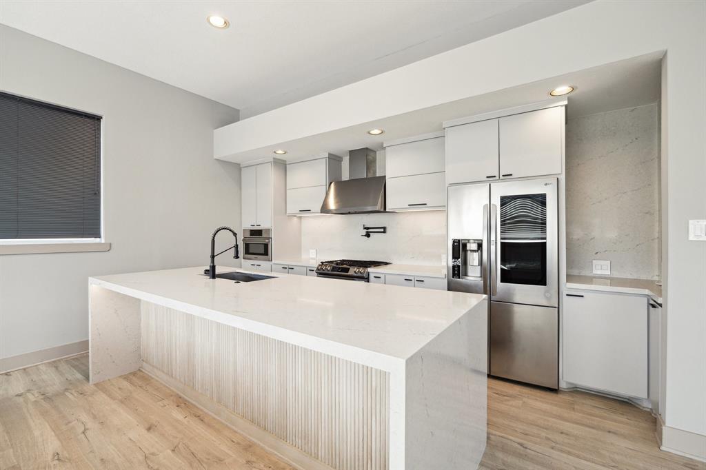 a kitchen with stainless steel appliances a sink stove and refrigerator