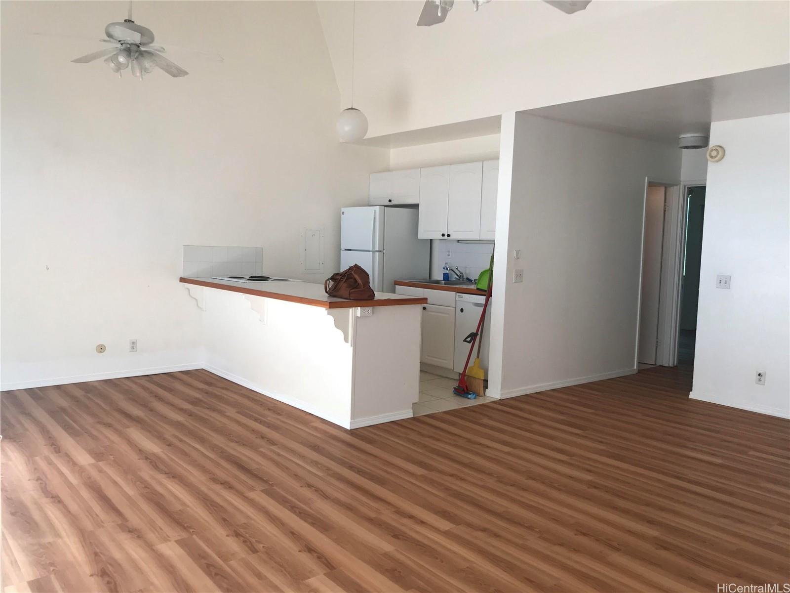 a kitchen with a wooden floor and white walls