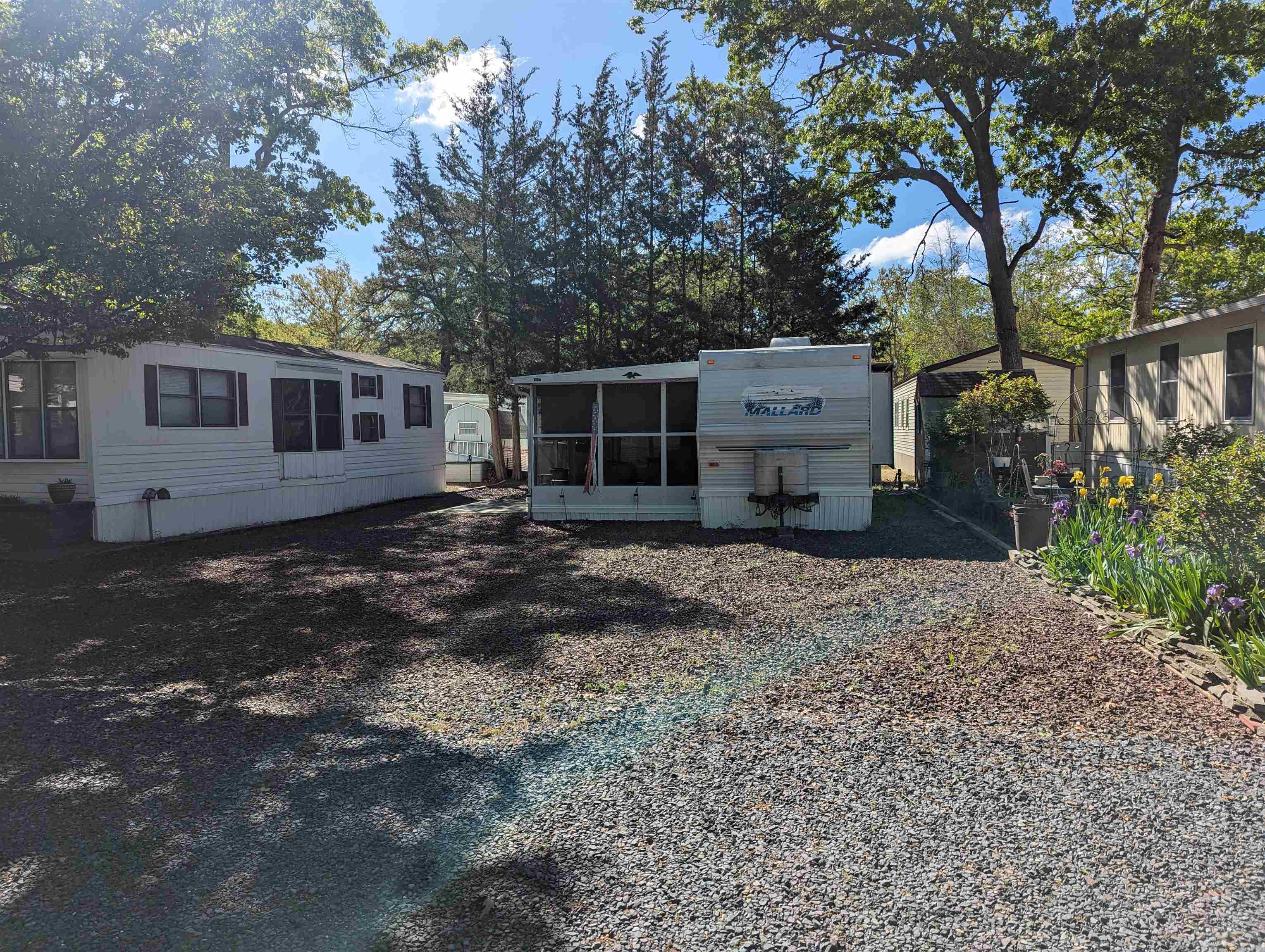 a backyard of a house with barbeque oven and trees