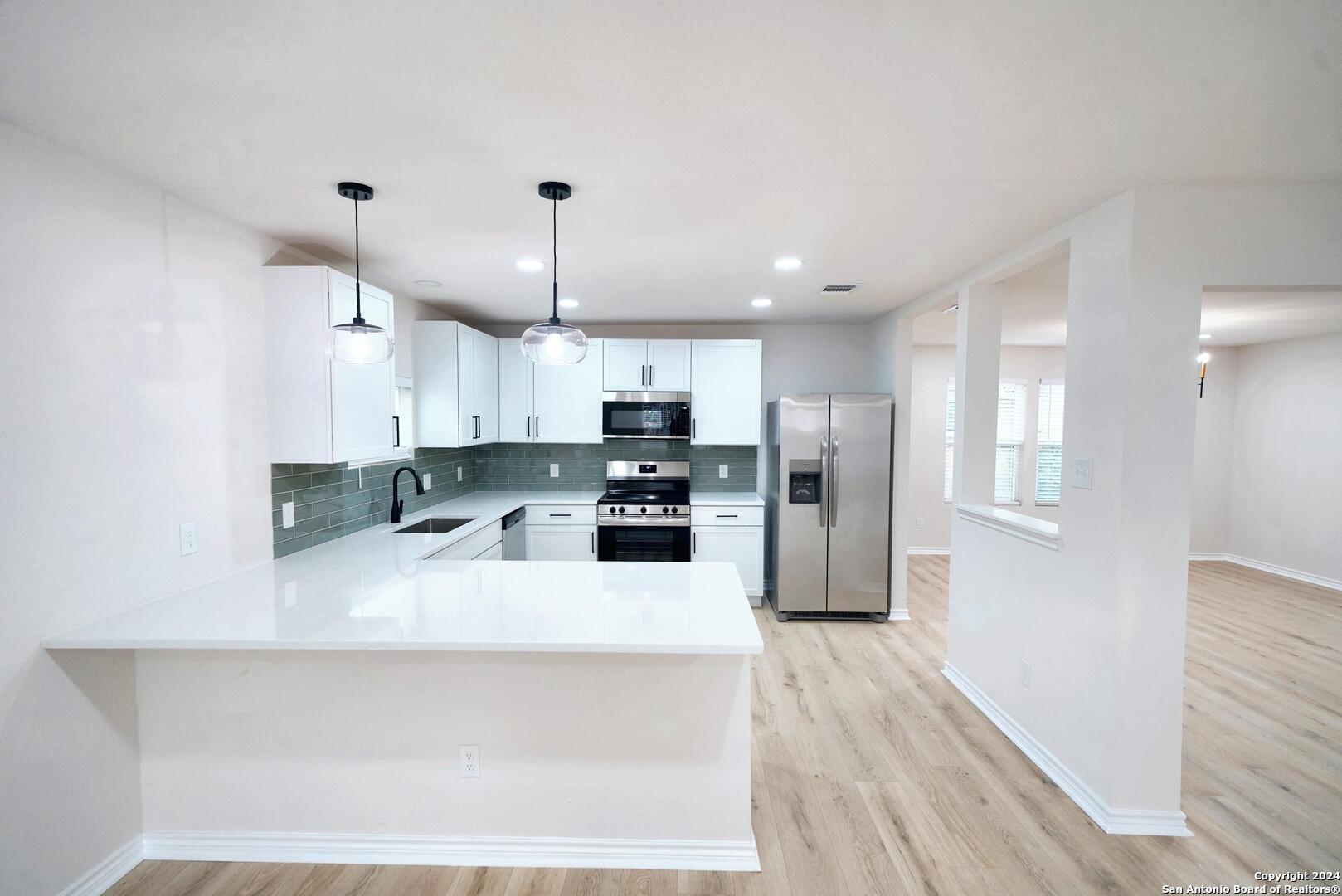 a kitchen with stainless steel appliances a refrigerator sink and microwave