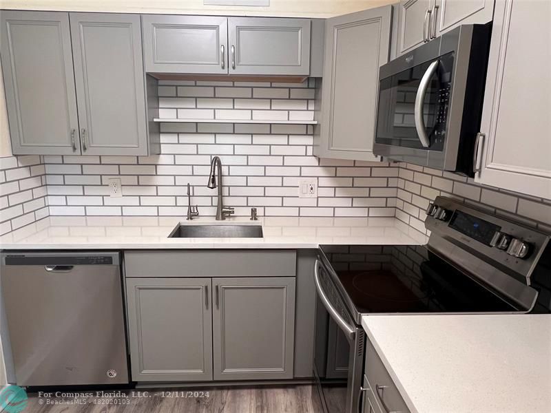 a kitchen with stainless steel appliances a sink stove and cabinets