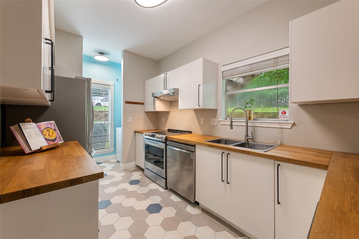 a kitchen with stainless steel appliances granite countertop a sink stove and refrigerator