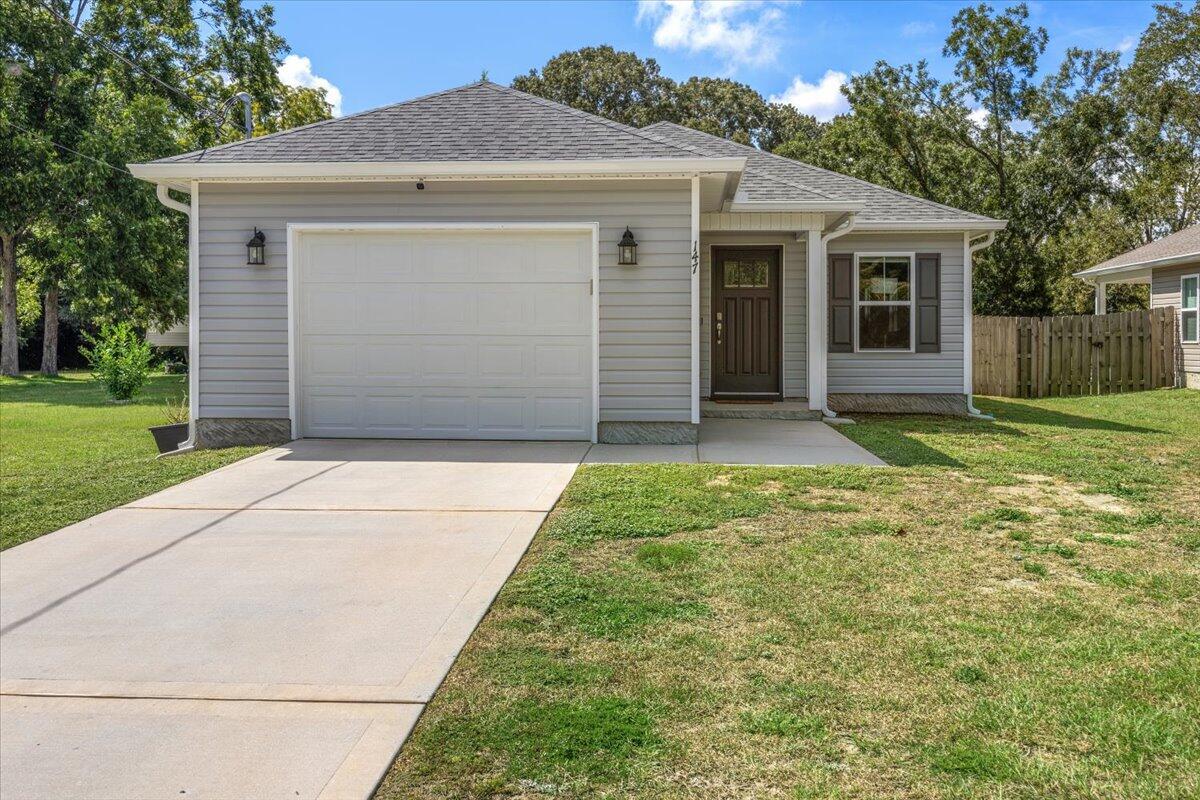 a view of a house with a yard and garage