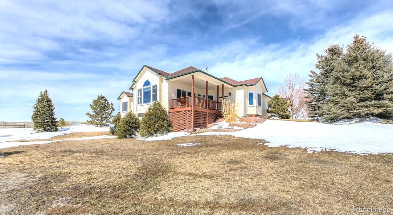 a front view of a house with a yard covered in snow