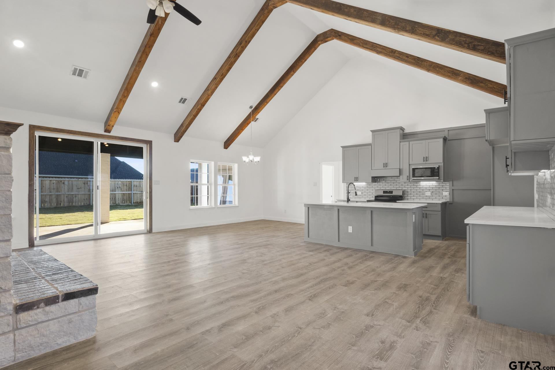 a large kitchen with stainless steel appliances granite countertop a stove and a sink with cabinets