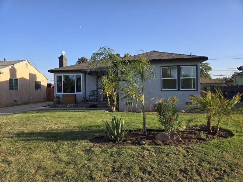 a front view of a house with a garden