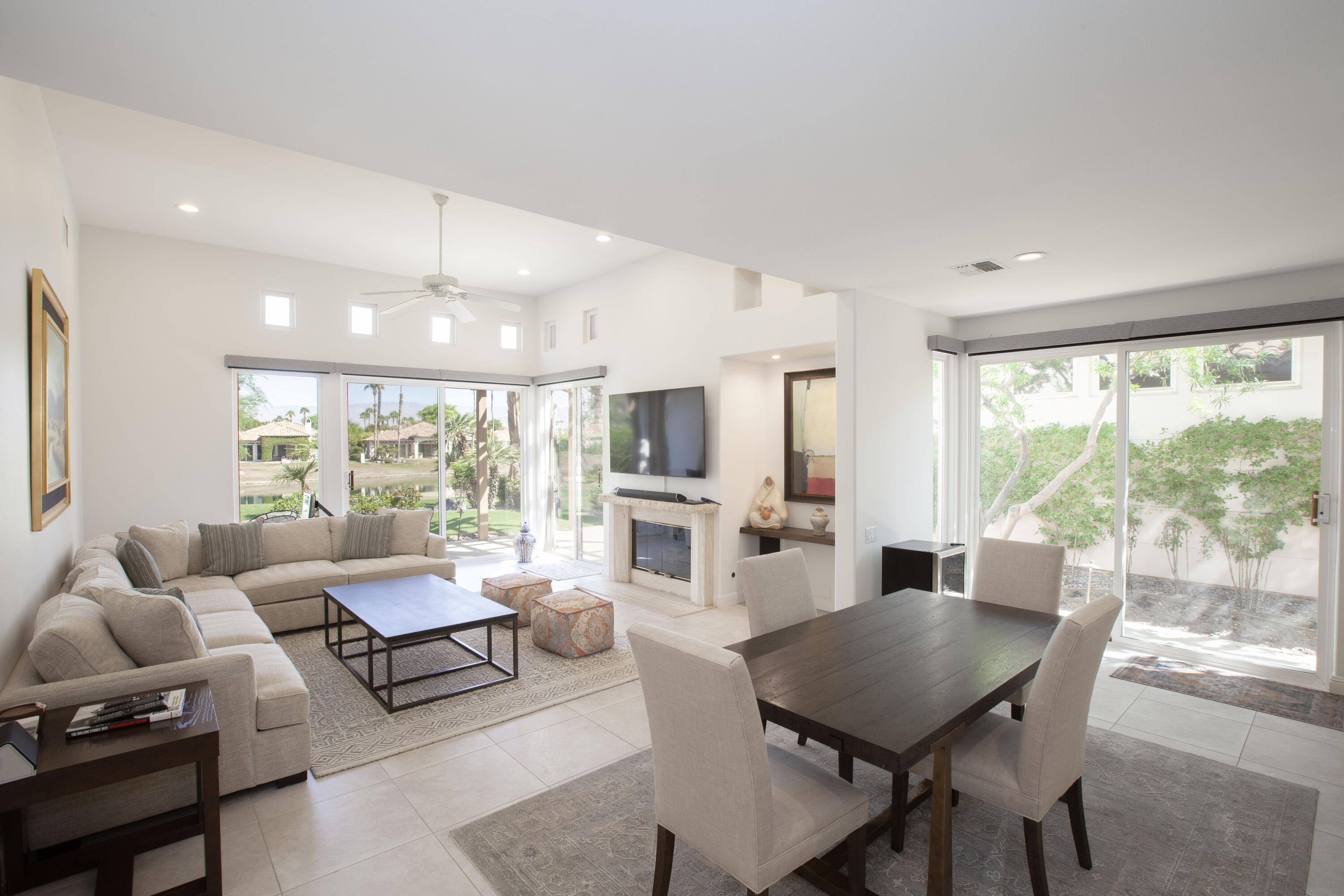 a living room with furniture a flat screen tv and a large window