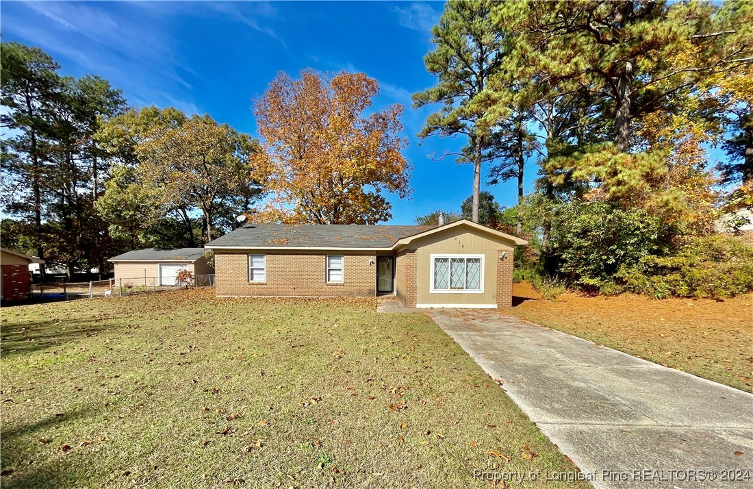 a front view of a house with a yard and trees