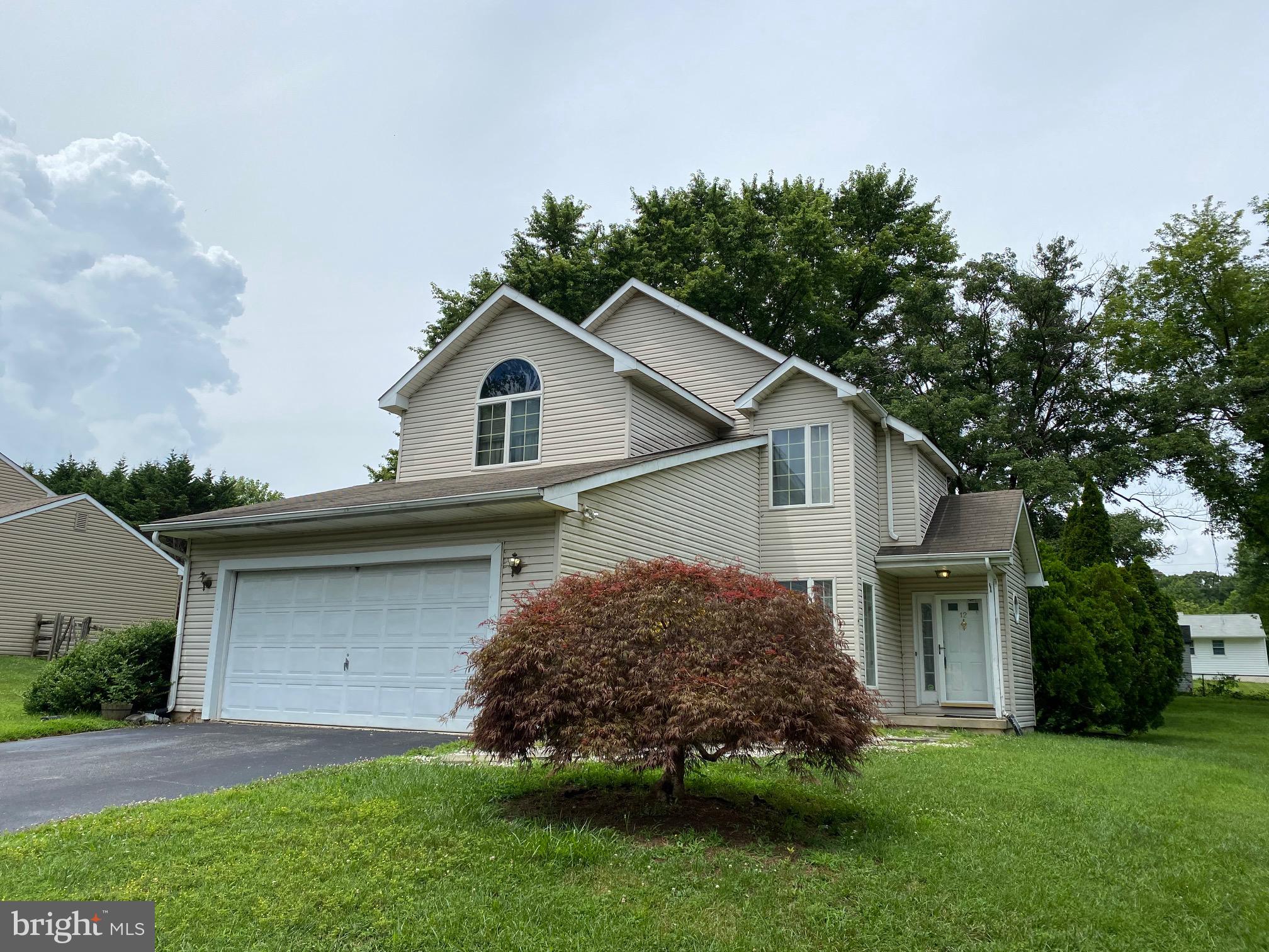 a front view of a house with a garden and plants