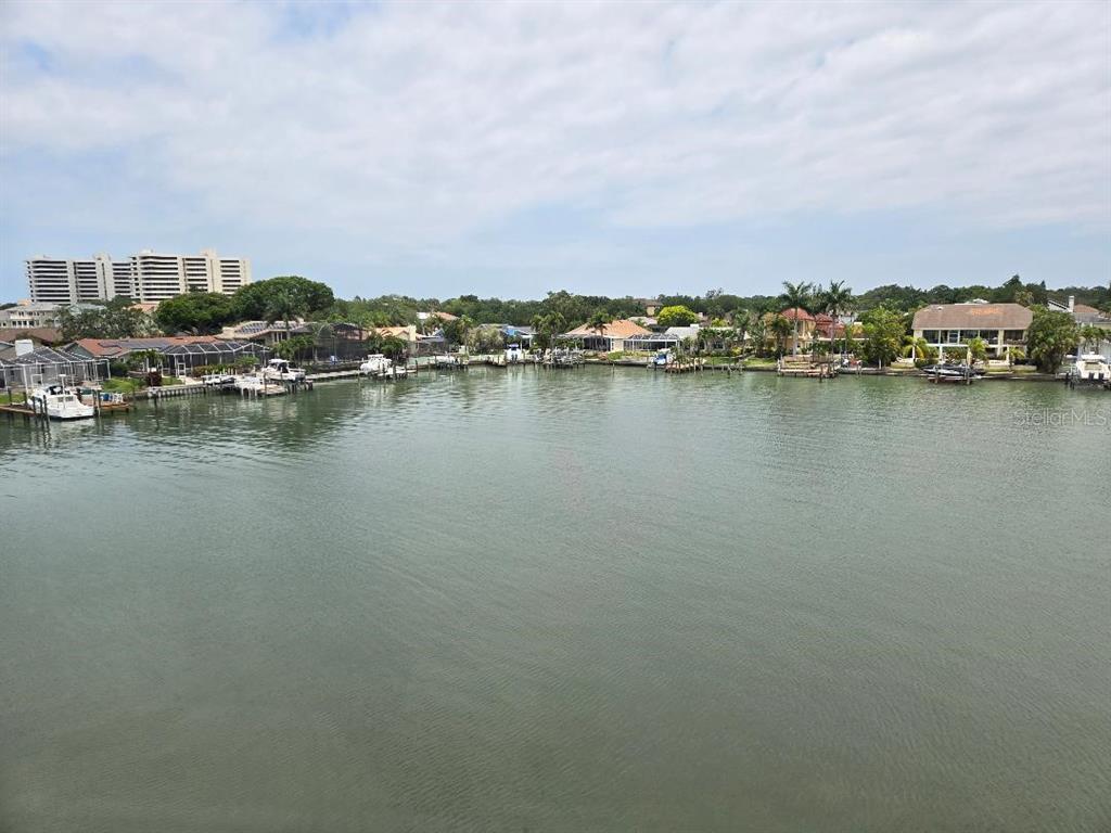 an aerial view of ocean and residential houses with outdoor space