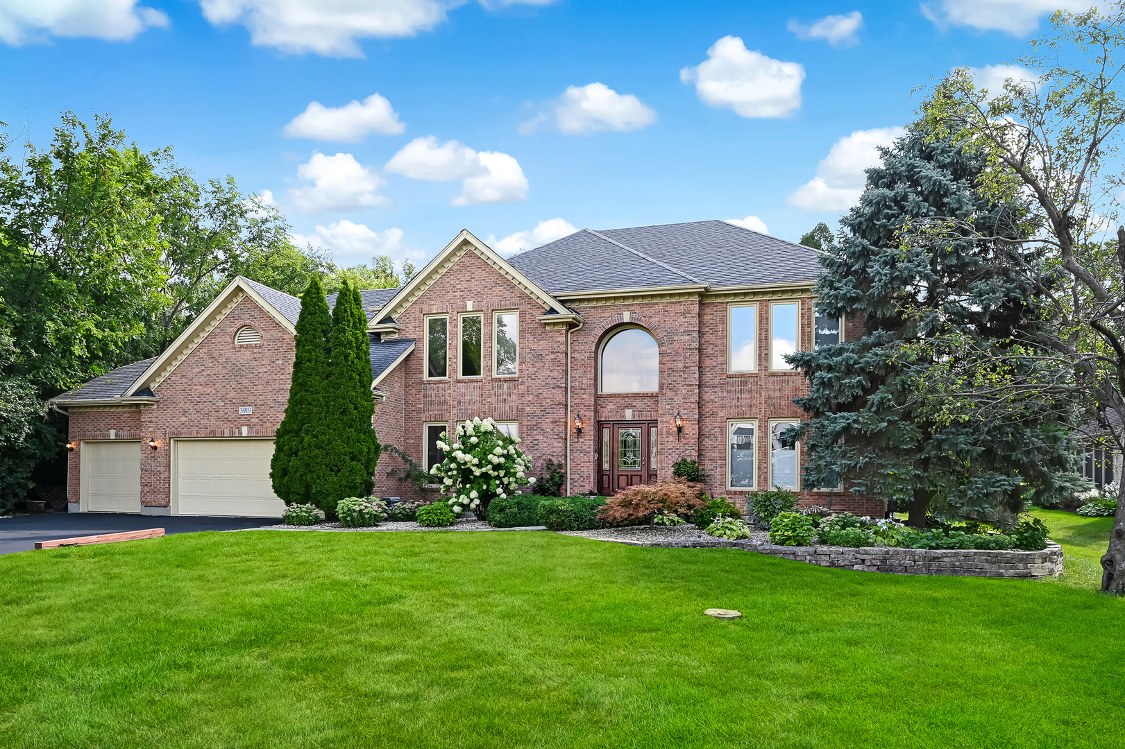 a front view of a house with a garden and plants