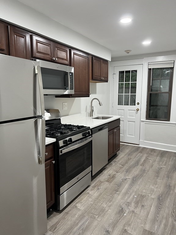 a kitchen with stainless steel appliances granite countertop a stove a sink and a refrigerator