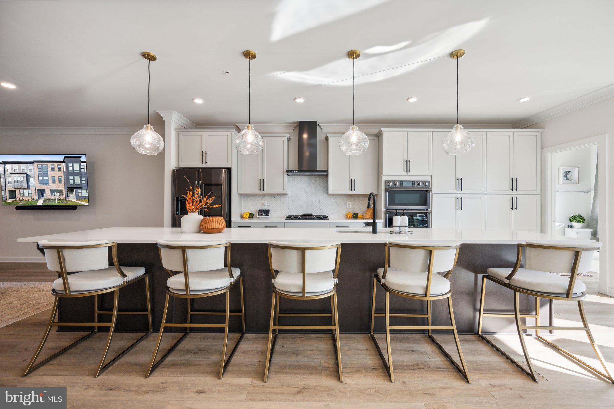 a kitchen with kitchen island a dining table chairs and white cabinets