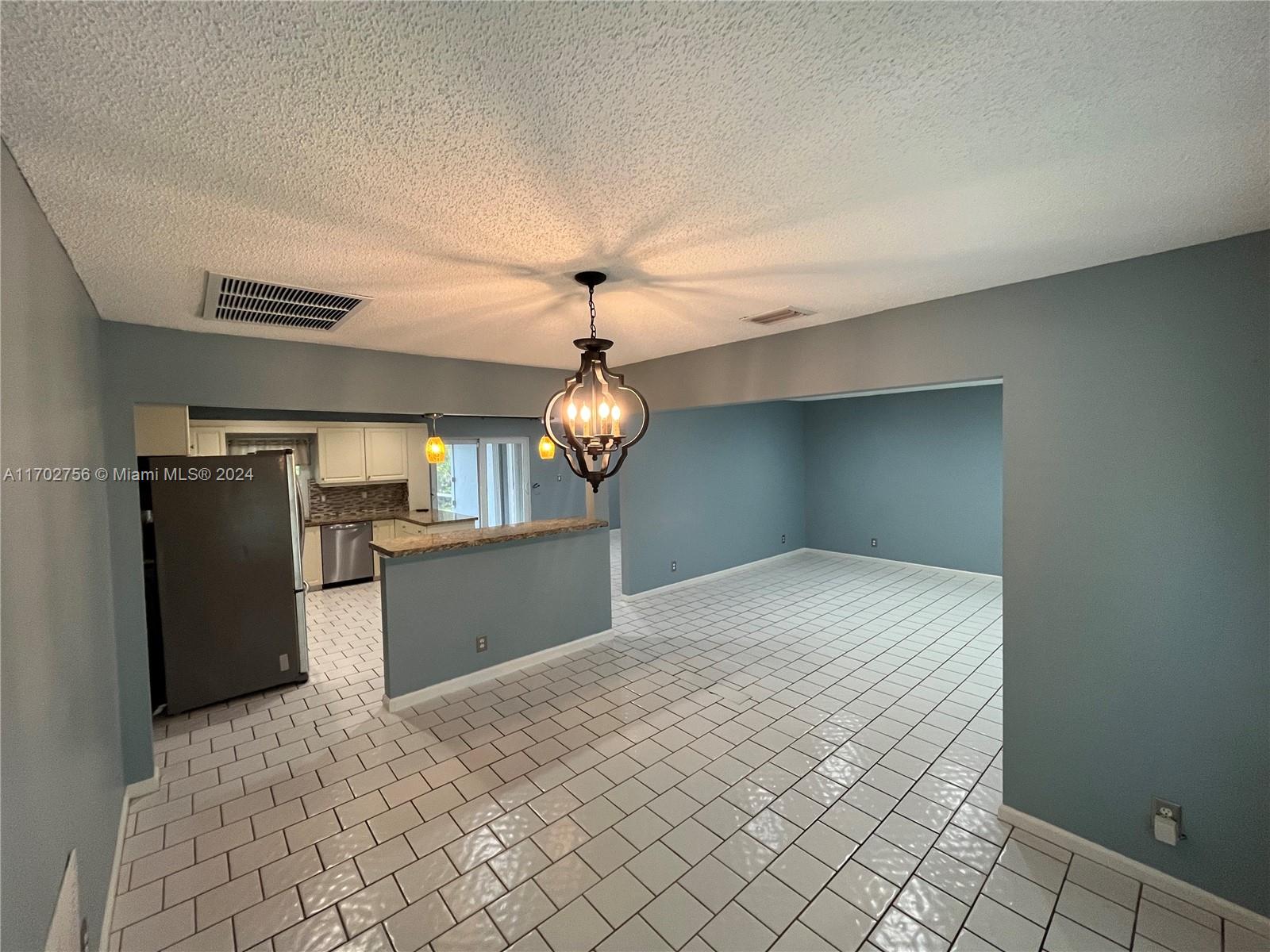 a view of a kitchen with a sink and refrigerator