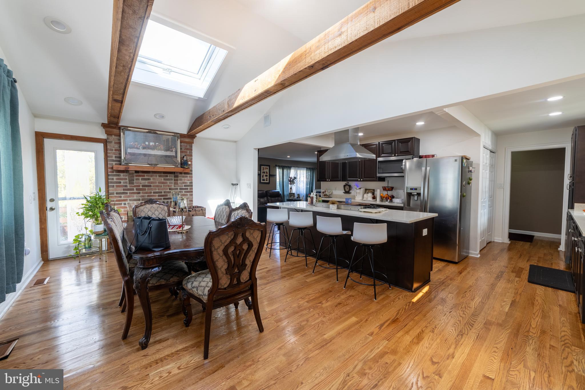 a living room with stainless steel appliances kitchen island granite countertop furniture wooden floor and a kitchen view