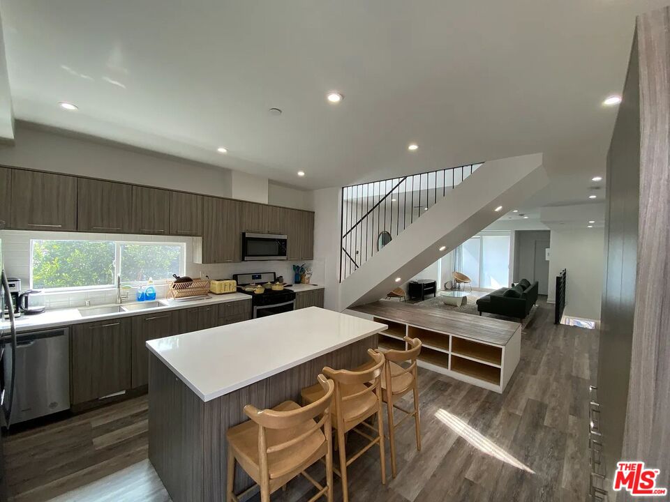 a kitchen with stainless steel appliances kitchen island a table and chairs in it