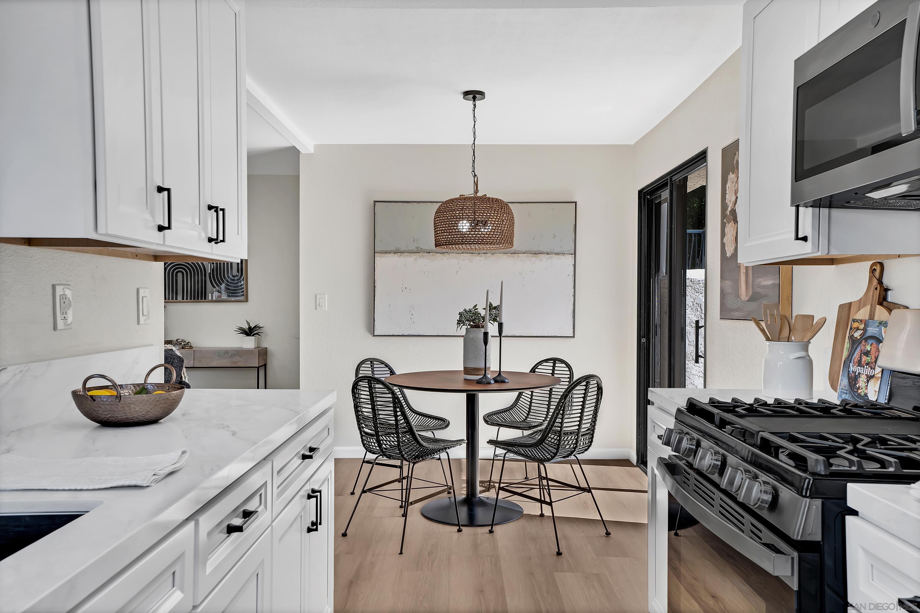 a kitchen with stainless steel appliances a table chairs and a wooden floor