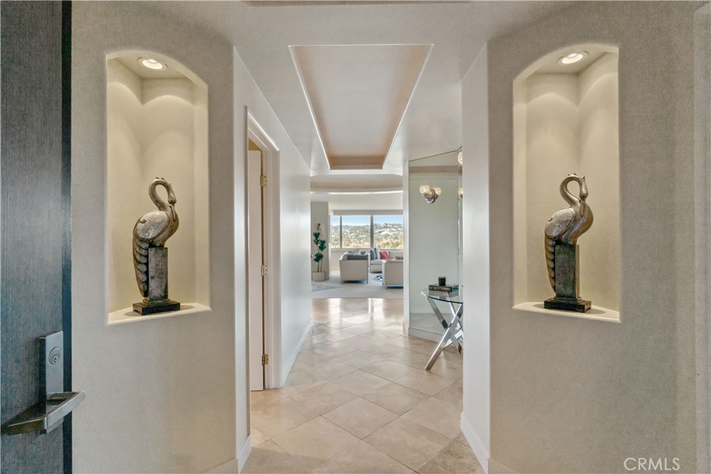 a view of a hallway with wooden floor and a living room