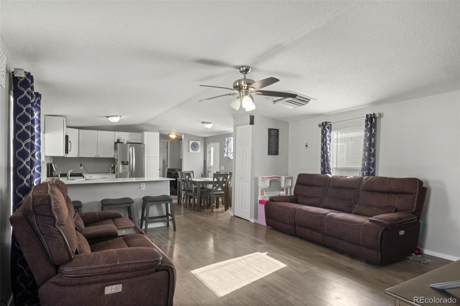 a living room with furniture kitchen view and a chandelier