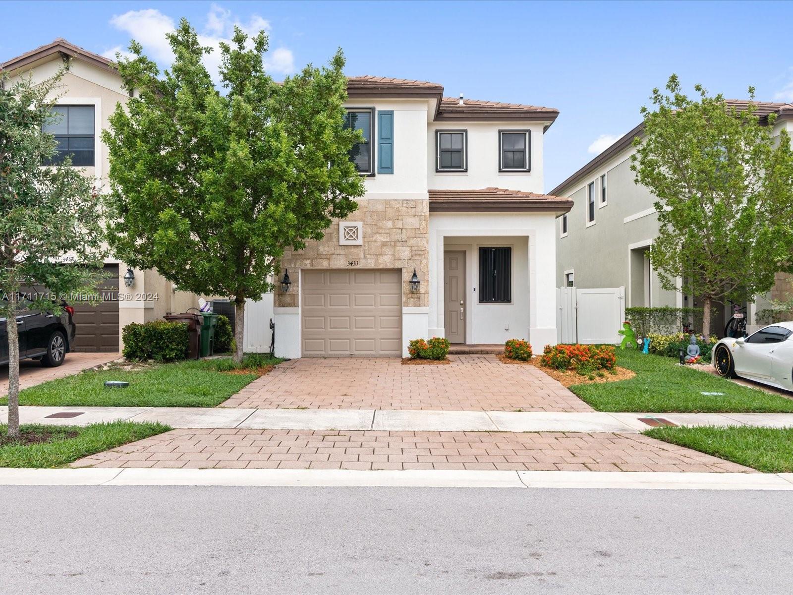 a front view of a house with a yard and a garage