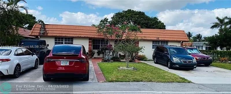 a front view of a house with a garden and parking space