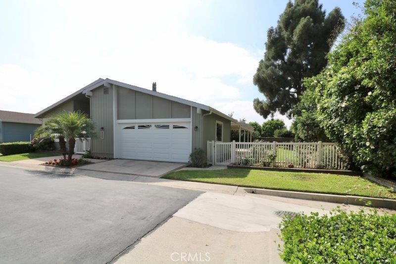 a view of a house with a yard and a large parking space